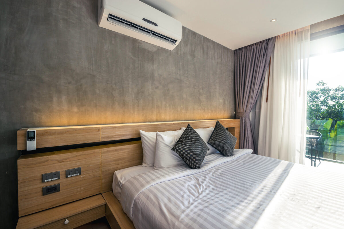 Bedroom with wall-mounted air conditioning unit.